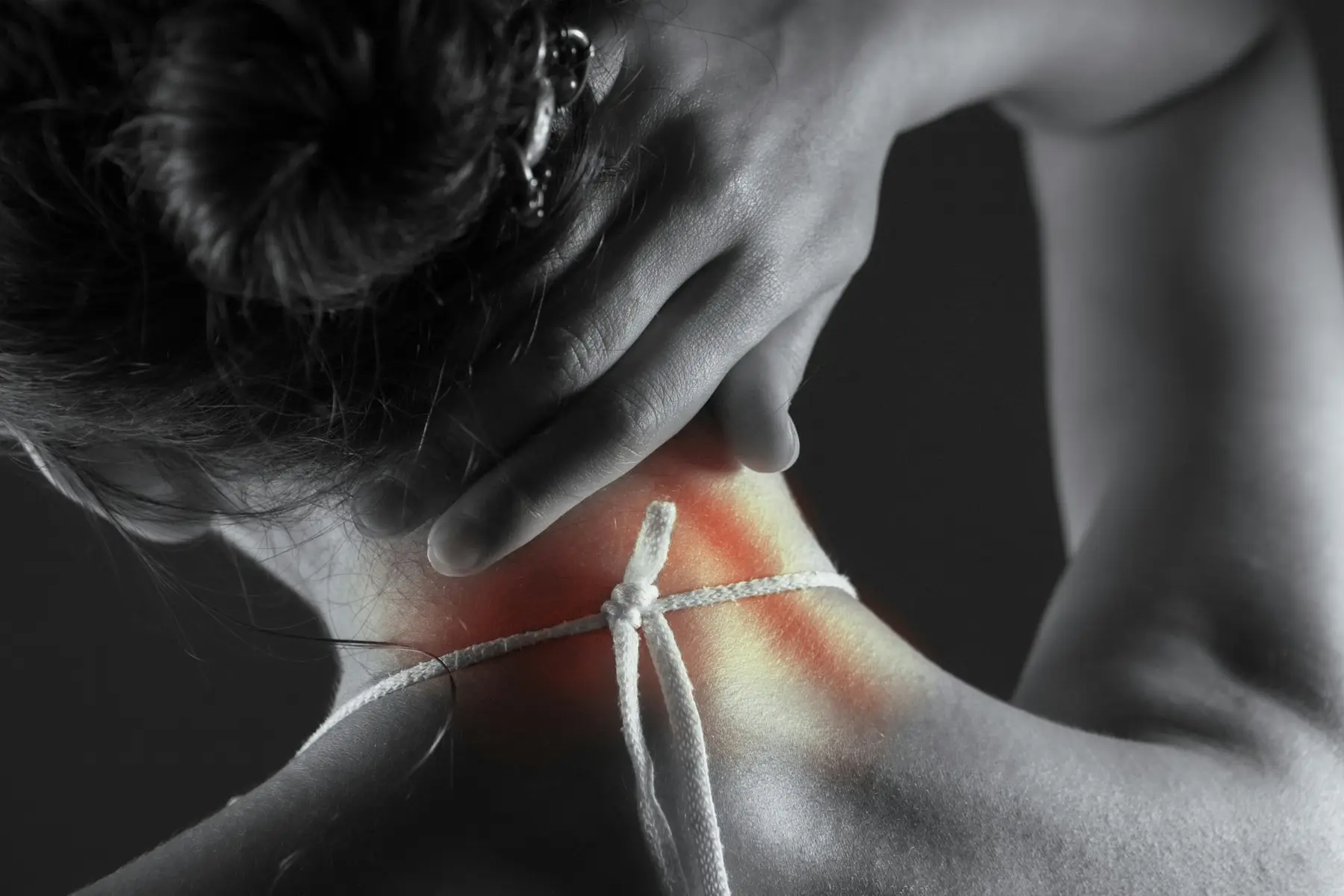 A hand reaching to the back of a neck.